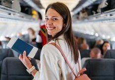 Young woman is happy boarding a plane because she no longer has Fear of Flying thanks to hypnotherapy in perth.